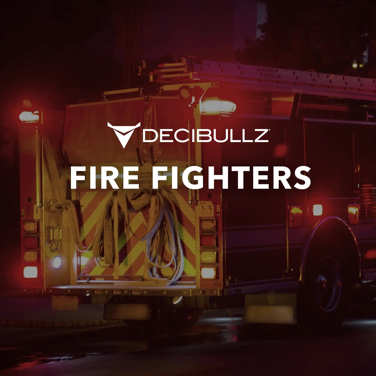 A fire truck with rear lights illuminated is shown at night. The text "DECIBULLZ FIRE FIGHTERS" is overlaid on the image. The fire truck, equipped with hoses and gear, promotes the Two-Way Surveillance Acoustic Tube Headset (Motorola), ensuring clear communication in critical moments.
