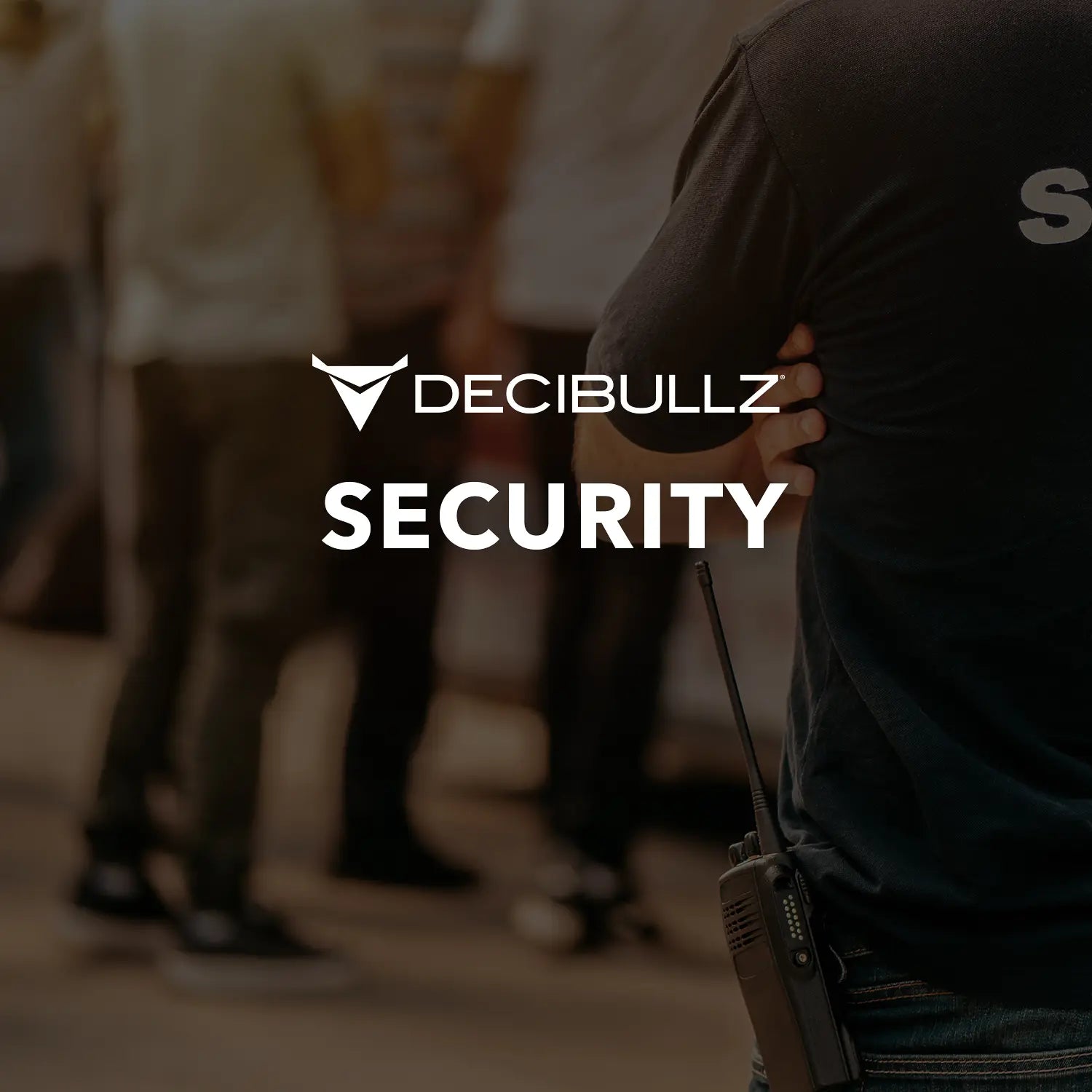 A person wearing a black T-shirt with "SECURITY" written on it is standing with their hand on their hip, carrying a portable radio. They're using an advanced acoustic tube technology headset, likely a Two-Way Surveillance Acoustic Tube Headset (Motorola) by Decibullz. Several people are visible in the blurred background. The word "DECIBULLZ" and a logo are displayed at the center of the