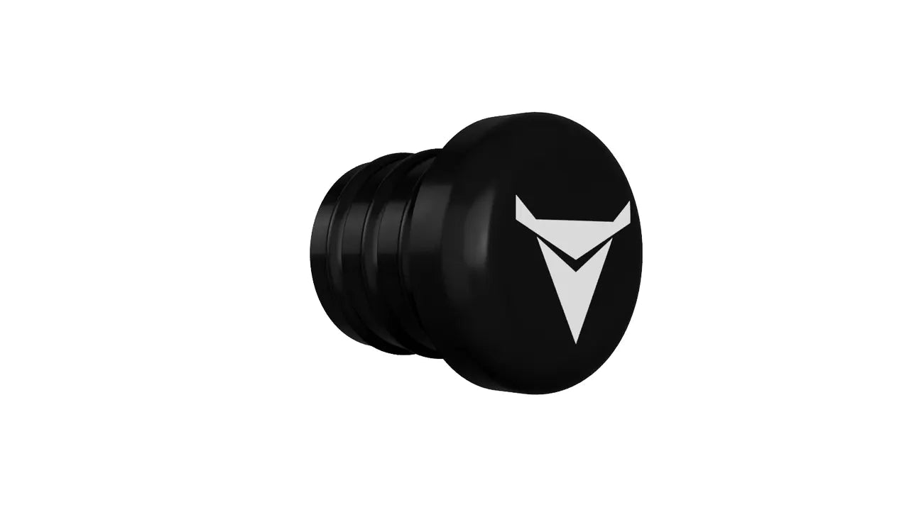 The image shows a black cylindrical object with a slightly wider, rounded end displaying a white triangular logo. The body has several horizontal grooves, and the object resembles the Decibullz REPLACEMENT Single Back Plug set against a plain white background.
